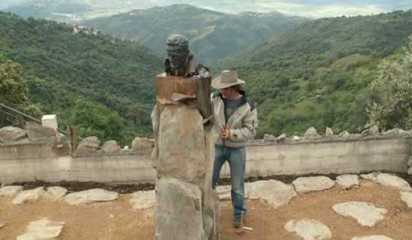 Le sculpteur Olivier Graïne à côté du buste de Mouloud Mammeri en Kabylie.