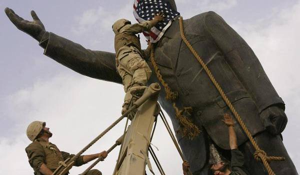 Les soldats américains à Bagdad devant la statue du dictateur.